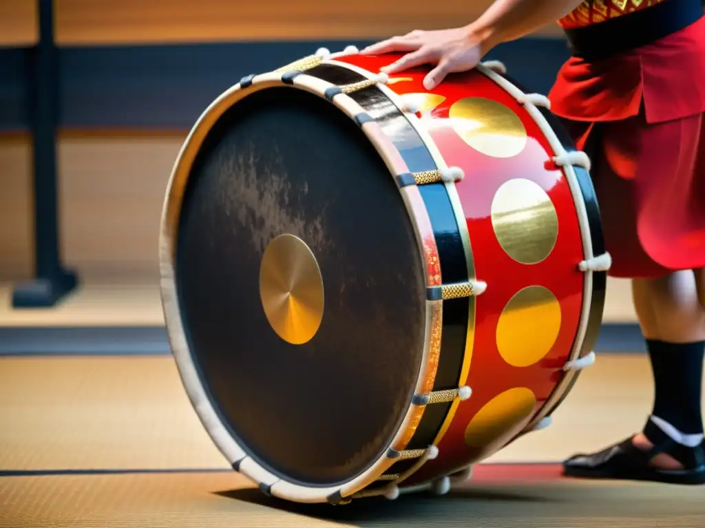 Un taiko japonés con diseños rojos y dorados es golpeado por un músico, mostrando la expresión cultural samurái a través de la música y la danza